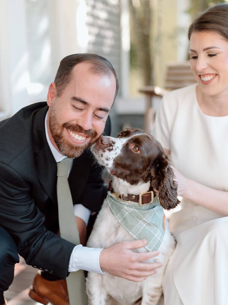 Couple wearing wedding attire with their dog